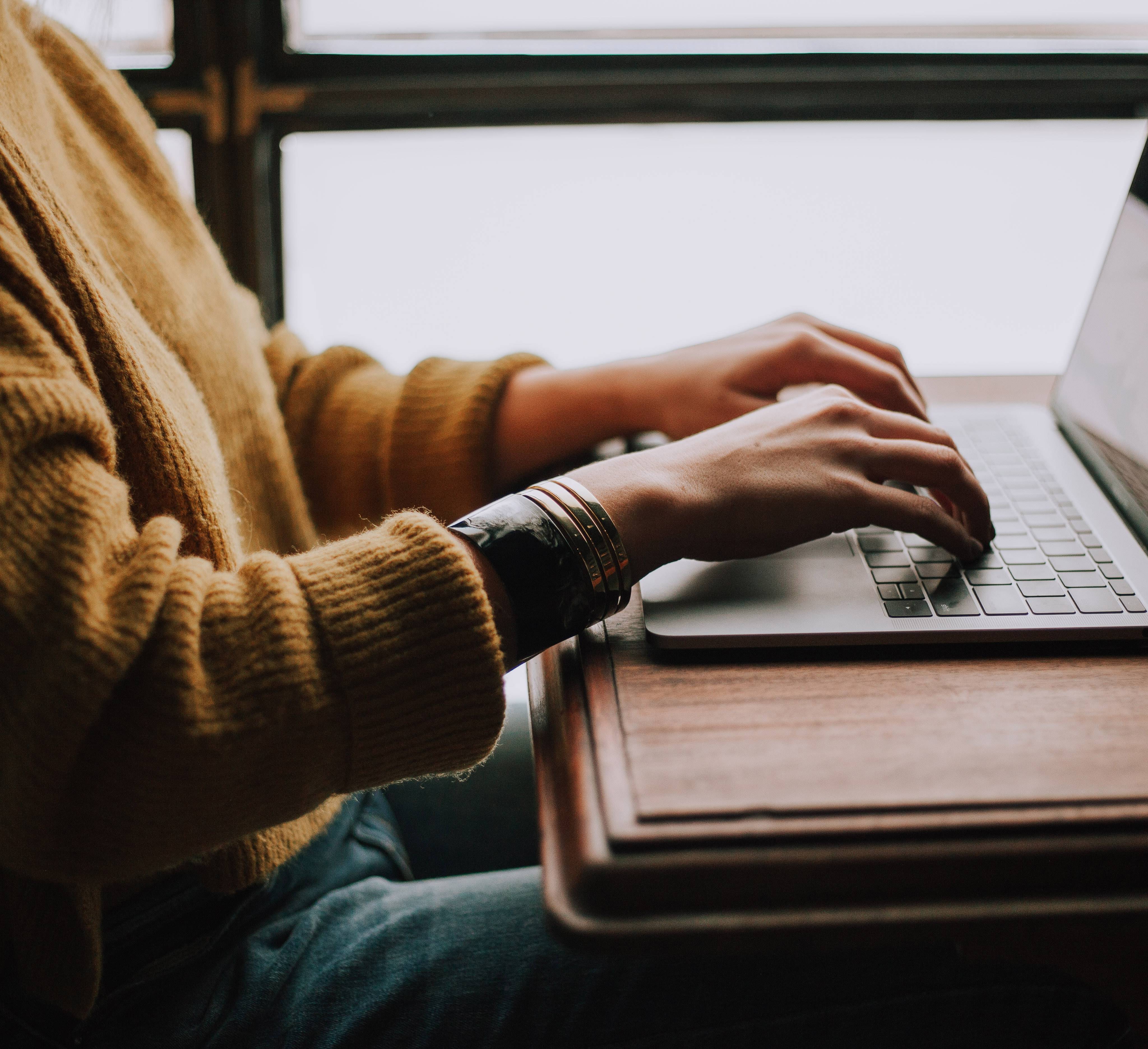 Frau schreibt an MacBook